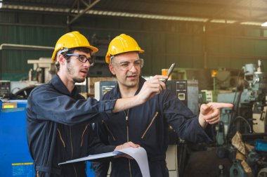 Endüstriyel işçiler büyük sanayi tesislerinde pek çok cihazlı projeler üzerinde çalışıyorlar..
