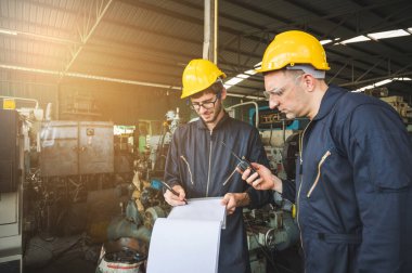 Endüstriyel işçiler büyük sanayi tesislerinde pek çok cihazlı projeler üzerinde çalışıyorlar..