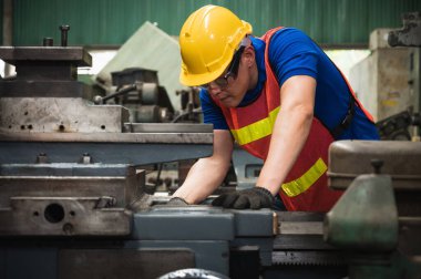Asyalı endüstriyel işçiler büyük sanayi tesislerinde pek çok cihazlı projeler üzerinde çalışıyorlar.