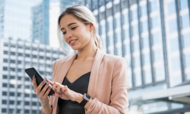 Ofiste telefonu kullanan gülümseyen genç bir iş kadını portresi..