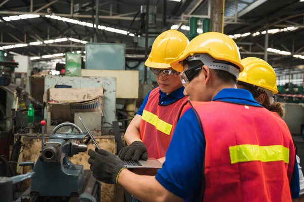 这个工业工人小组正在一家拥有许多设备的大型工业工厂里从事各种工程 — 图库照片
