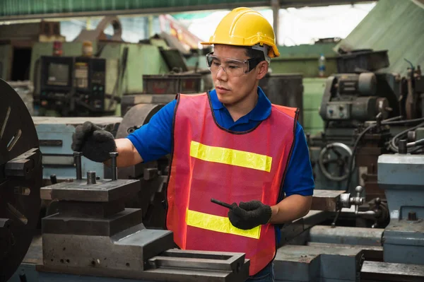 Asian Industrial workers are working on projects in large industrial plants with many devices.