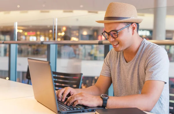 Ung Asiatisk Man Med Hatt Använder Laptop För Sitt Arbete — Stockfoto
