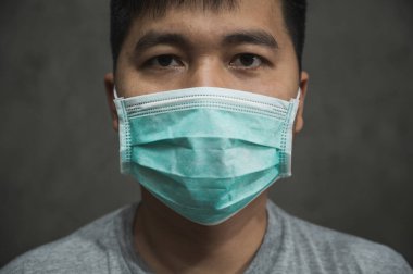 Korunaklı yüz maskesi takan Asyalı genç adamı Coronavirus 'a karşı kapatın..