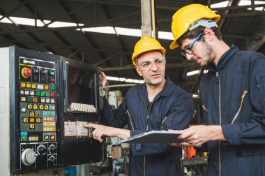 Endüstriyel işçiler büyük sanayi tesislerinde pek çok cihazlı projeler üzerinde çalışıyorlar..