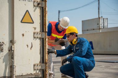 Foreman ve rıhtım çalışanları kargo limanında pano tutuyor. Ticari Lojistik İthalat İhracat Nakliye Konsepti.
