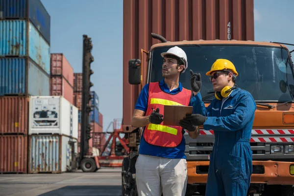 Foreman and dock worker staff working checking at Container cargo harbor holding clipboard. Business Logistics import export shipping concept.