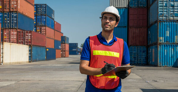 Форман держит планшет, работающий в контейнерной грузовой гавани. Концепция импорта логистики
.