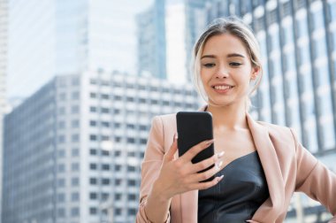 Ofiste telefonu kullanan gülümseyen genç bir iş kadını portresi..