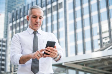 Telefon kullanan kıdemli iş adamının portresi