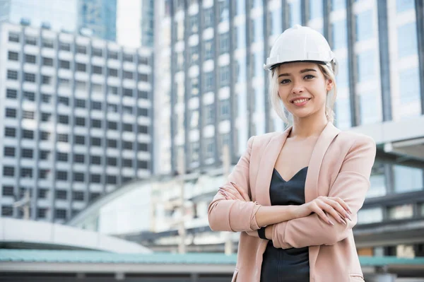 Portrait of pretty young civil engineer woman on construction building background. Evolution construction concept.