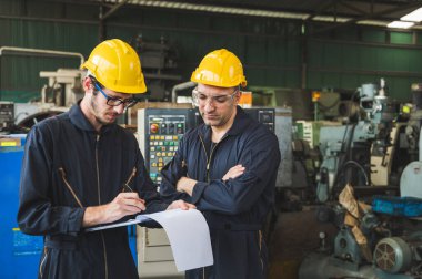 Endüstriyel işçiler büyük sanayi tesislerinde pek çok cihazlı projeler üzerinde çalışıyorlar..