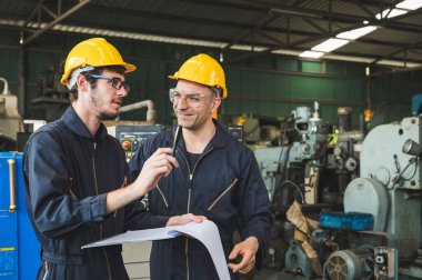 Endüstriyel işçiler büyük sanayi tesislerinde pek çok cihazlı projeler üzerinde çalışıyorlar..