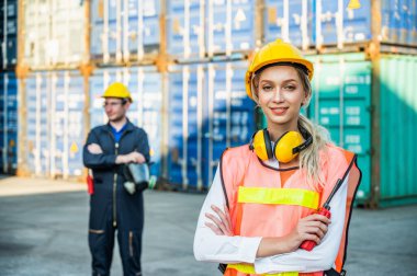 Konteyner kargo limanında çalışan iki işçi ve kadın işçi konteynırları yüklemeye çalışıyor. Rıhtım erkeği ve kadın personel lojistik ihracat nakliyat konsepti.