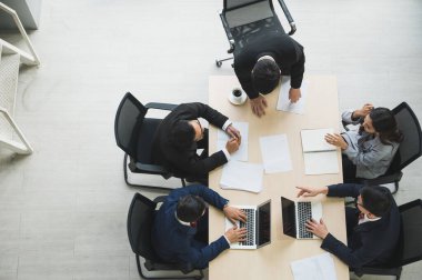 Asyalı iş adamlarının istatistik analizi takımının en üst görüşü. İş adamlarından oluşan bir ekibin yüksek açılı görüşü Toplantı Konferansı Kurumu Konsepti ofiste.