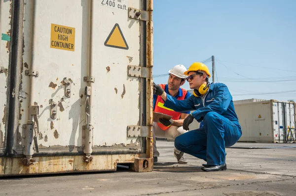 Foreman and dock worker staff working checking at Container cargo harbor holding clipboard. Business Logistics import export shipping concept.