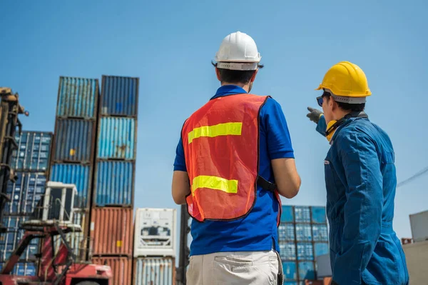 フォアマンとドックの従業員が指を指してコンテナ貨物港で働いています ビジネス物流輸出入輸送コンセプト — ストック写真