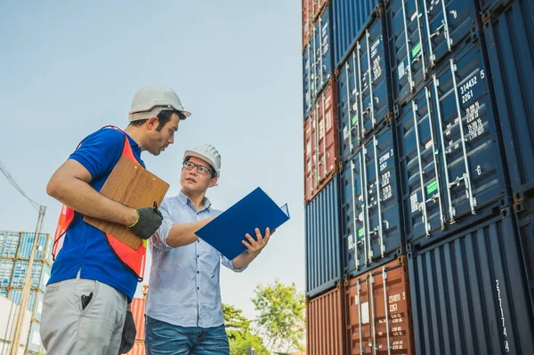 Foreman and dock worker staff working checking at Container cargo harbor holding clipboard. Business Logistics import export shipping concept.