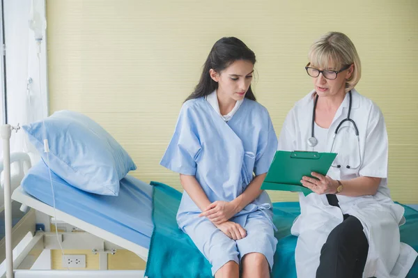 Doctora Mayor Reúne Con Paciente Discutiendo Consulta Tomando Notas Sobre — Foto de Stock