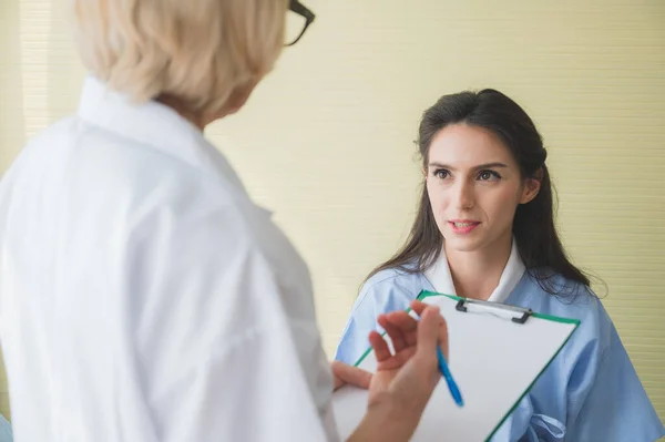 Senior Vrouwelijke Arts Patiënt Bespreken Aantekeningen Maken Symptoomprobleem Terwijl Het — Stockfoto