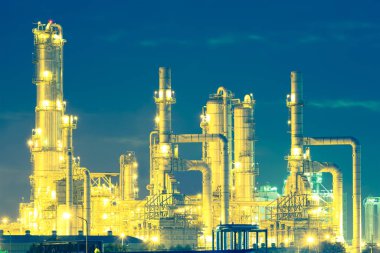 Alacakaranlıkta gökyüzü arkaplanlı petrol rafinerisi.
