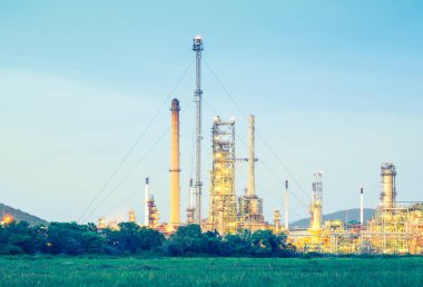 Alacakaranlıkta petrol rafinerisinin havalandırma kulesi.