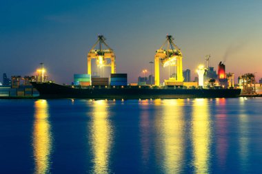 Kargo gemisi ve vinç bağlantı noktasında Nehri üzerinde twilight saat yansıtacak.