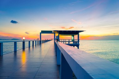 Alacakaranlık vakti deniz manzaralı ahşap köprü manzarası.