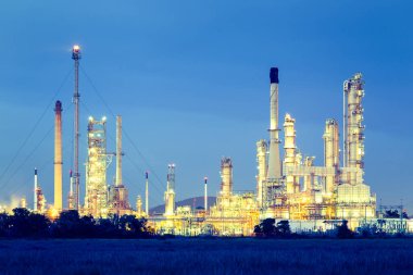 Alacakaranlıkta gökyüzü arkaplanlı petrol rafinerisi.