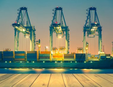 Kargo gemisi alacakaranlık vakti limanda konteynır boşaltıyor..