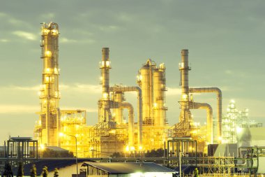 Alacakaranlıkta gökyüzü arkaplanlı petrol rafinerisi.