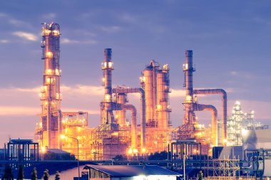 Alacakaranlıkta gökyüzü arkaplanlı petrol rafinerisi.