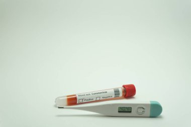 Koronavirüsün termometreyle kan testi. Kan tüpü pozitif. Termometre 40 derece gösteriyor, 2019-NCov 'un bir belirtisi..