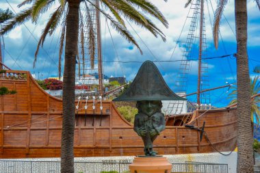 La Palma 'dan bir cüce, adanın bir özelliği. Arka planda bir donanma müzesi olan bir gemi var..