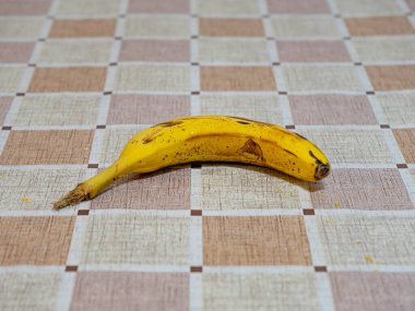 Kareli masa örtüsü olan olgun bir muz..