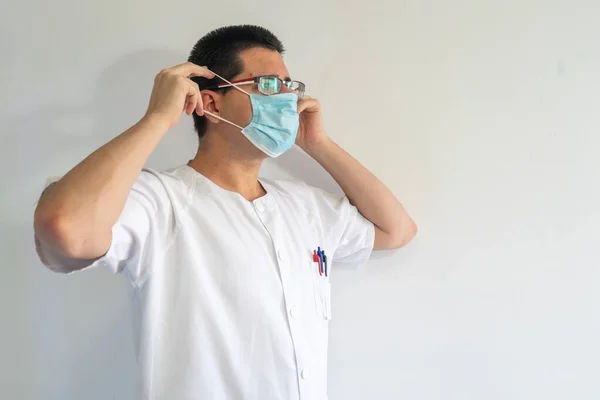 看護師は コロナウイルスから保護するためにマスクをつけてください 眼鏡をかけている 制服は白 — ストック写真