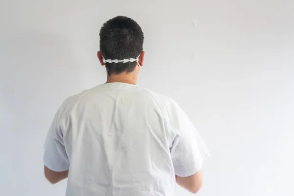 Doktor / hemşire koronavirüsten korunmak için maske takıyor. Mavi eldiven ve gözlük takıyor. Üniforması beyaz..