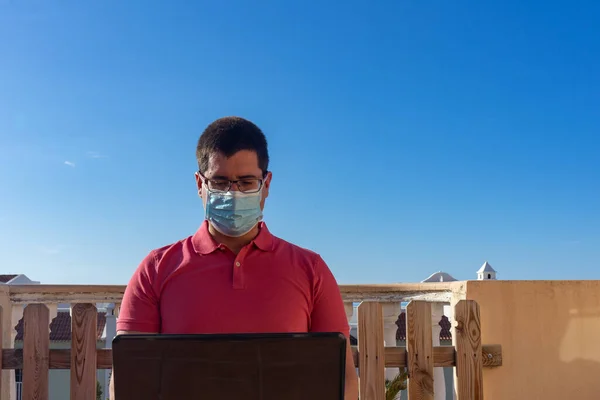 Hombre Con Una Máscara Trabajando Con Portátil Desde Balcón Casa — Foto de Stock