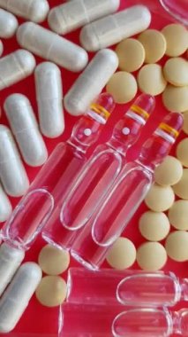 Makro kırmızı arka planda uyuşturucu ve hapları birleştiriyor.