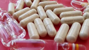 Makro kırmızı arka planda uyuşturucu ve hapları birleştiriyor.