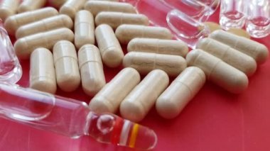 Makro kırmızı arka planda uyuşturucu ve hapları birleştiriyor.