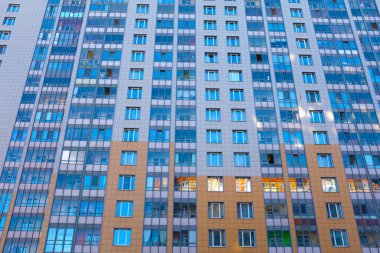 Güneşte balkonları olan çok katlı bir ev.