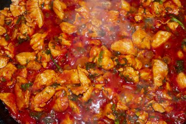 Domates soslu kızarmış et ve ateşte otlar.