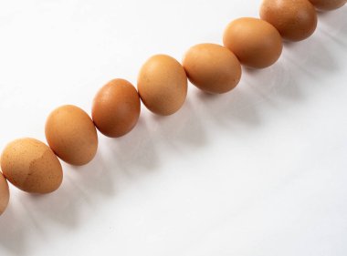 Yumurtalarını beyaz bir masanın üzerine bıraktı.