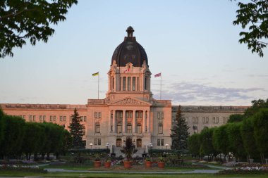 Önünde güzel bir park olan büyük kubbeli bir bina. Yasama binası, Wascana Gölü, Regina, Sakatchewan, Kanada