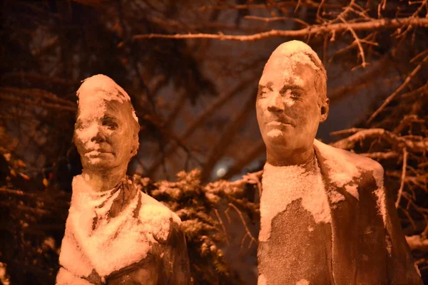 Bronze heads covered with snow. Regina Lace, detail. Monument to diverse immigrant population and immigration history. City Hall Queen Elizabeth II Courtyard fountain, Regina, Saskatchewan, Canada.
