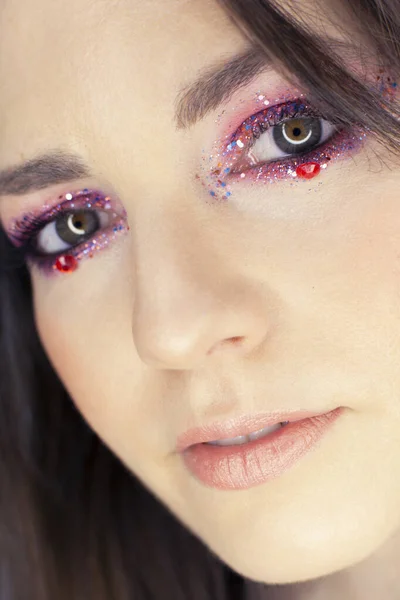 close-up of young woman with glitter makeup on eyes