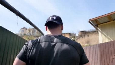 Adam deniz kenarında, kumsalda antrenman yapıyor, denize ve kuma bakıyor, boks yapıyor, koşuyor, telefonda konuşuyor, deniz taşı fırlatıyor.