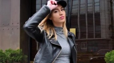 Fransız tarzı bir Fransız kadın, şehir merkezinde küçük bir etekle yürüyor, elinde bir çanta, ayakkabılarını düzeltmek için eğiliyor, sokak lambalarının etrafında dönüyor, gülümsüyor.