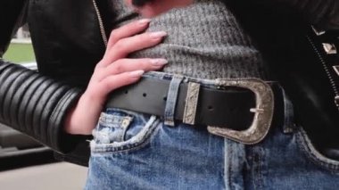 Fransız tarzı bir Fransız kadın, şehir merkezinde küçük bir etekle yürüyor, elinde bir çanta, ayakkabılarını düzeltmek için eğiliyor, sokak lambalarının etrafında dönüyor, gülümsüyor.